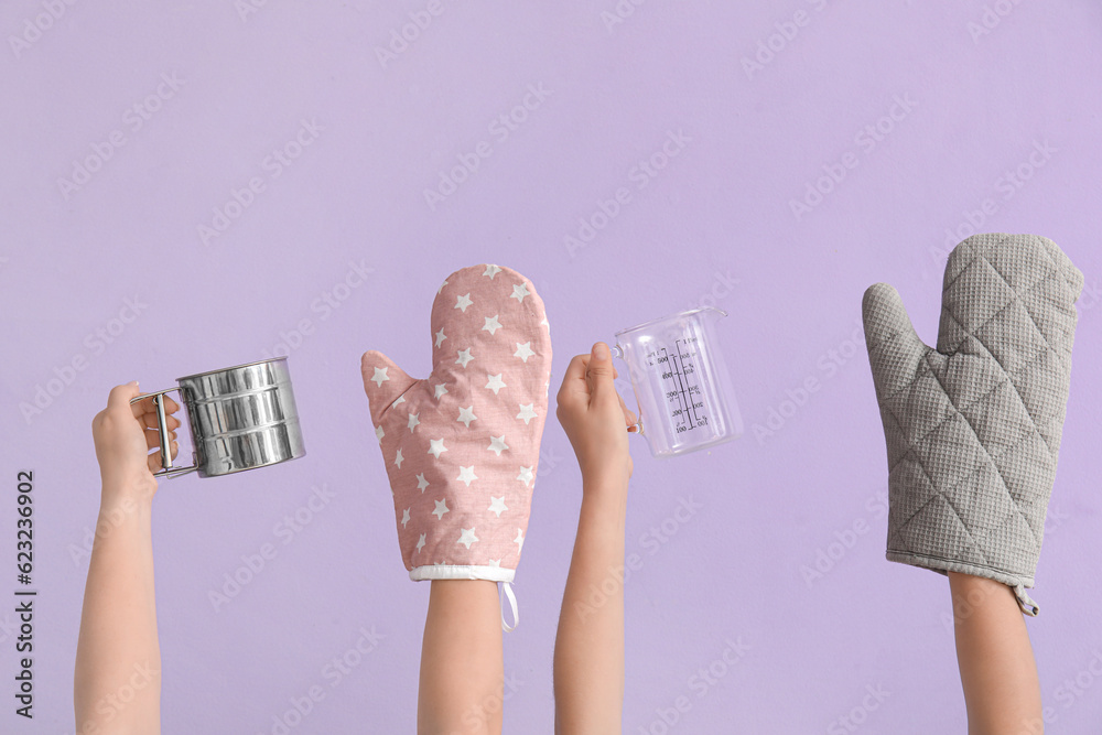 Obraz na plátně Female hands with baking utensils on lilac background
