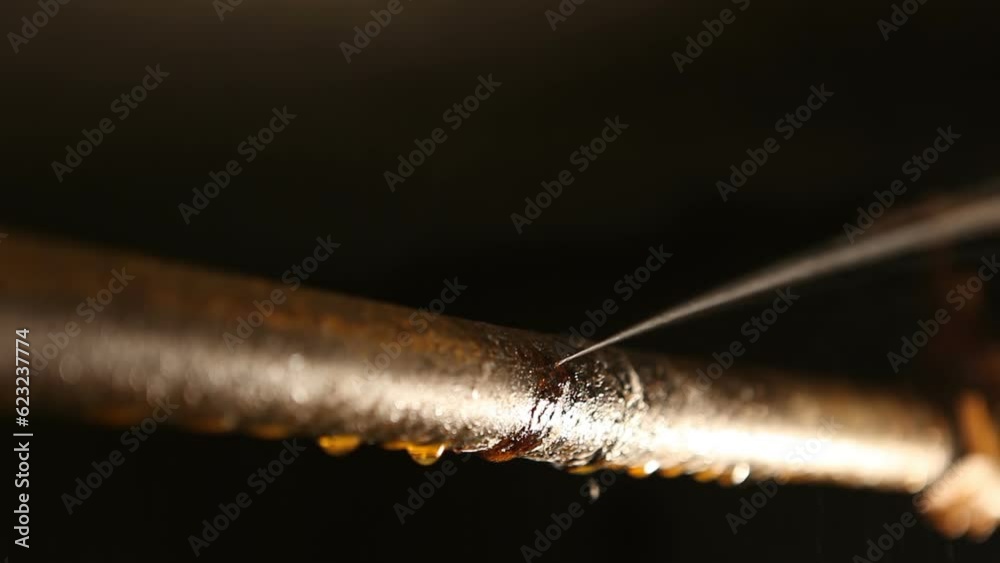 Rusty water pipe leaking under pressure. Fistula in the water pipe, in the basement.