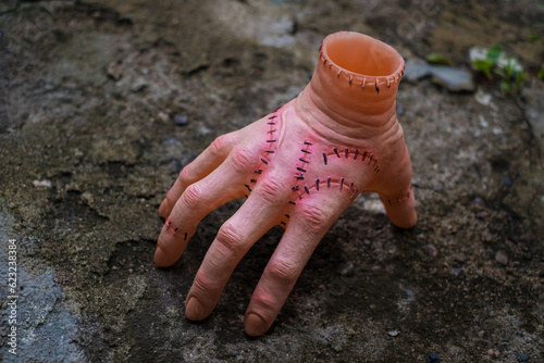 Scary realistic human hand with scars and stiches. Cut off hand with active fingers. Plastic toy.