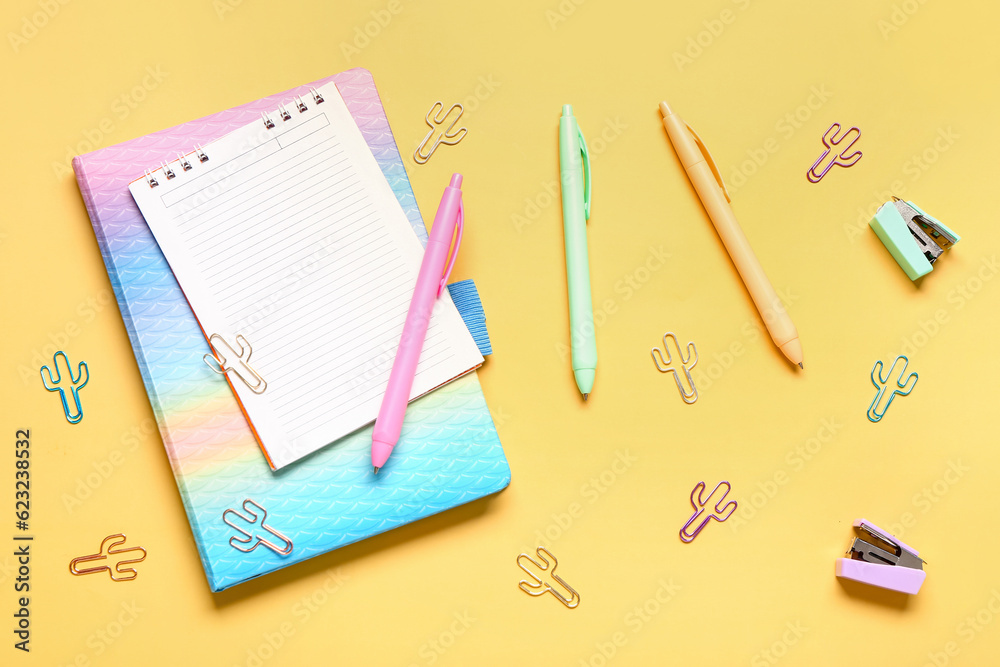 Different school stationery and blank notebook on yellow background Different school stationery and blank notebook on yellow background