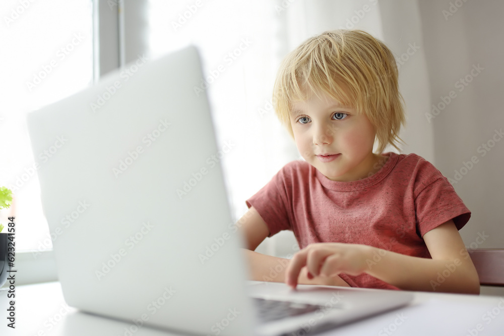 Schoolboy use computer app for study by laptop at home. Child and gadgets. Online education and distance learning for children Schoolboy use computer app for study by laptop at home. Child and gadgets. Online education and distance learning for children