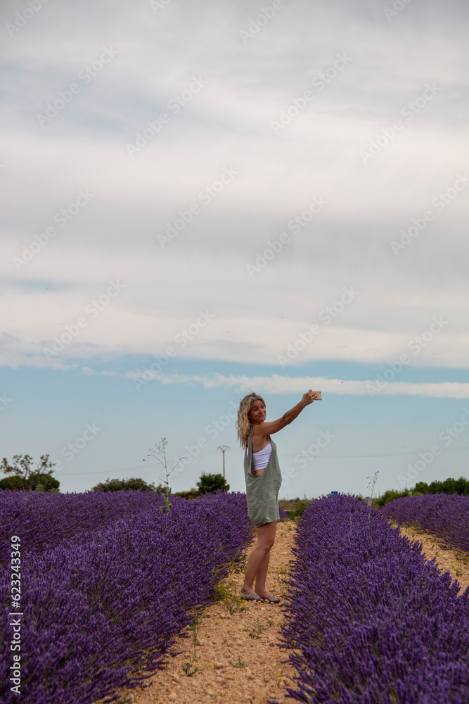 custom made wallpaper toronto digitalBlonde woman with mobile phone in hand enjoying her summer vacation in a blooming field of lavenders