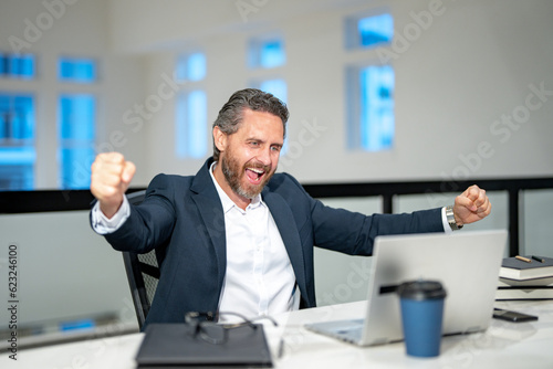 Business worker with laptop at office. Employee remote working in modern office. Business man on online meeting. Hispanic business man working online. Excited business man using laptop at workplace.