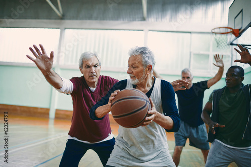 Seniors playing basketball in an indoor gym © Geber86