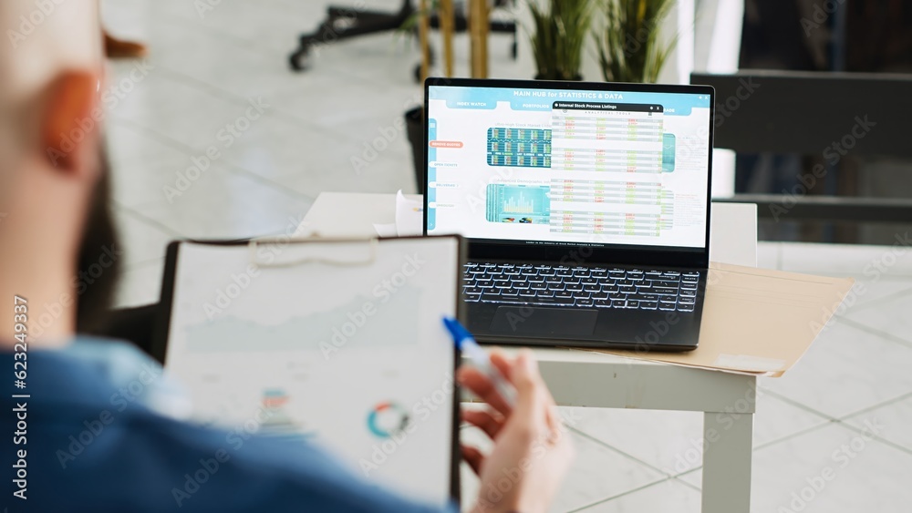 Fototapeta premium Startup consultant researching project using archived documents with analytics, working in business office. Company analyst looking at executive data papers, solving tasks at job. Handheld shot.