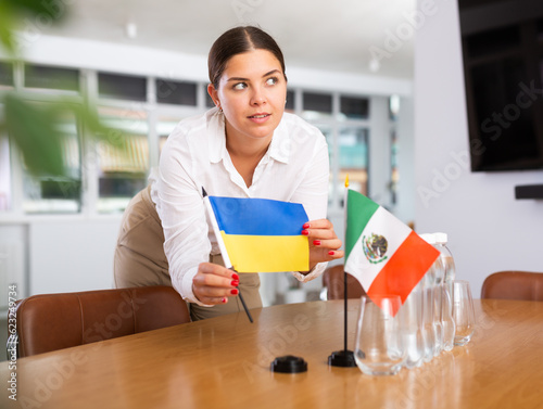 Secretary shows the flags of Mexico and Ukraine on the table. Preparing for a meeting, negotiations. photo