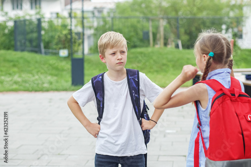 Two children, classmates, quarrel and yell on way from school. Conflict and negative emotion.