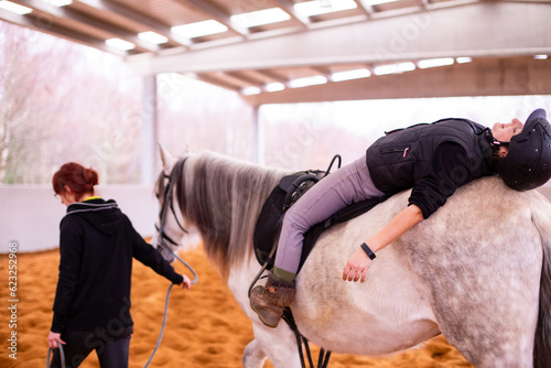Hippotherapy. Therapeutic wellness, occupational therapy mid-adult woman patient on horse school