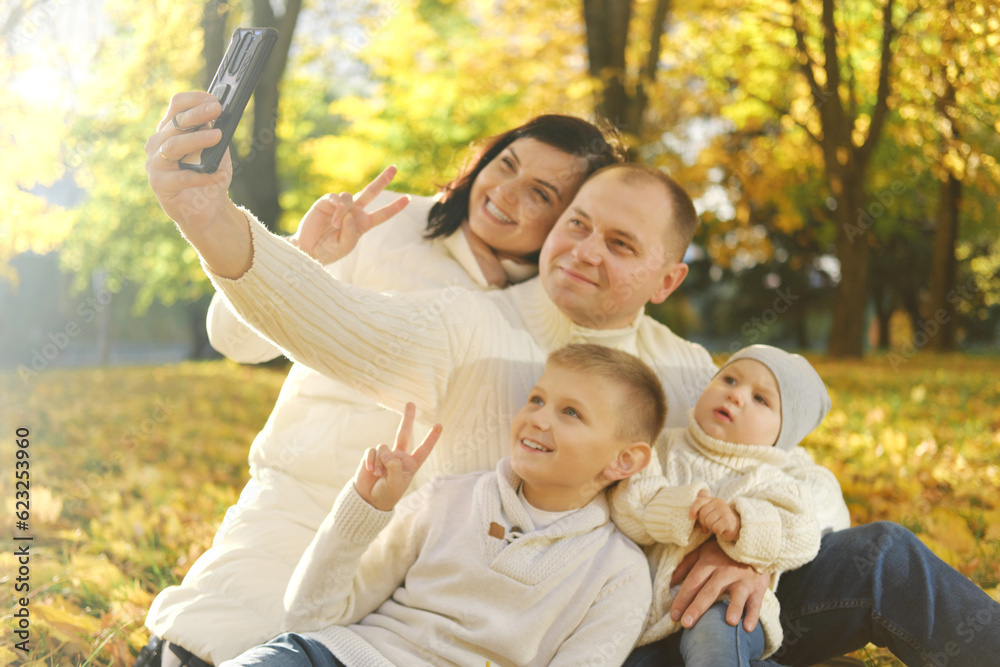 Smiling family on an autumns day in park make selfie photo. Smiling family on an autumns day in park make selfie photo.