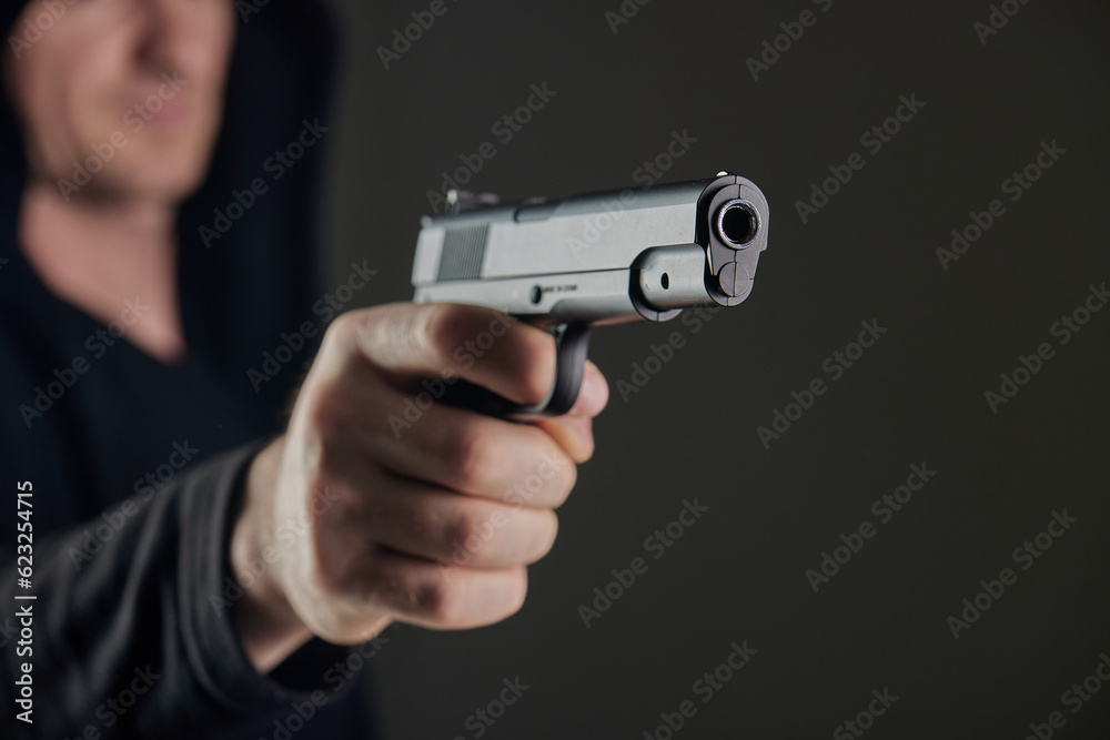 Male hand holding a gun on black background . A gun in a man's hand. defense or attack murderer or armed robber, First person view of a pistol. Male hand holding a gun on black background . A gun in a man's hand. defense or attack murderer or armed robber, First person view of a pistol.