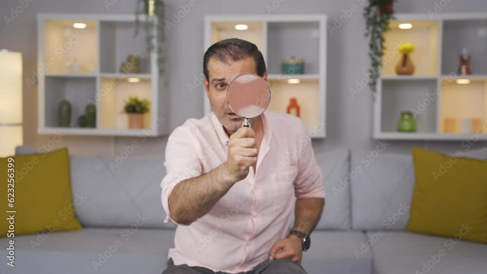 Man looking at camera with magnifying glass. Man looking at camera with magnifying glass.