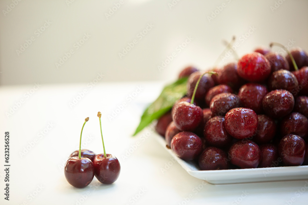 Juicy sweet cherry with water drops on a plate.