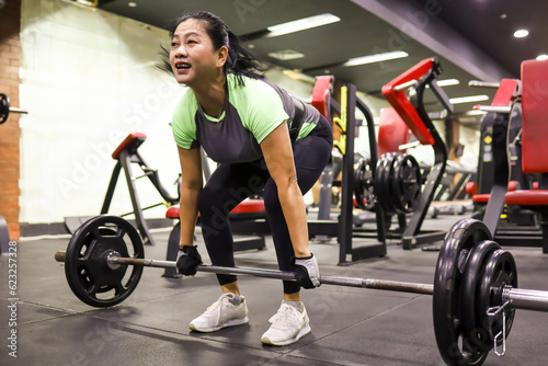 asian woman doing deadlift exercise in gym. Shout out for motivation