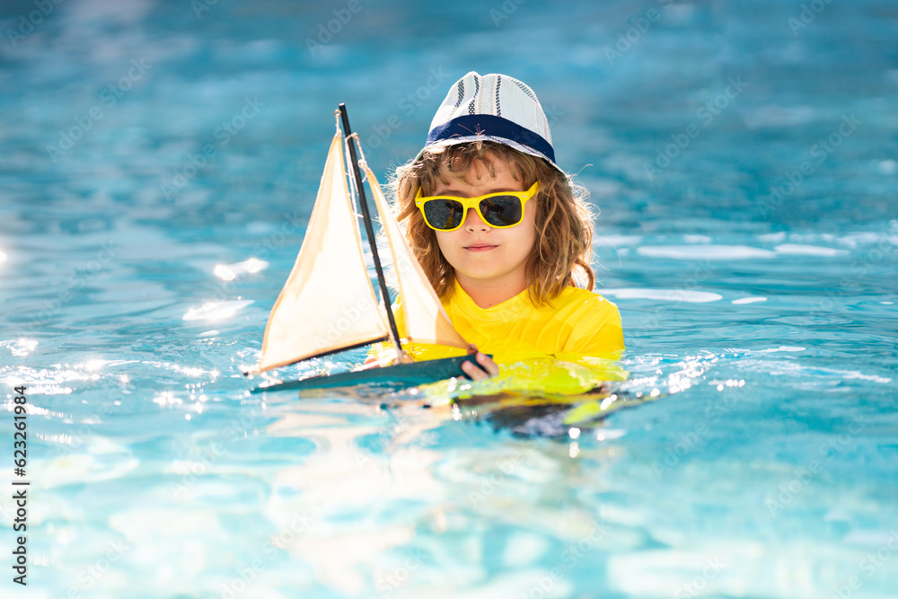 Kid with toy boat in sea water on summer vacation. Little kid playing