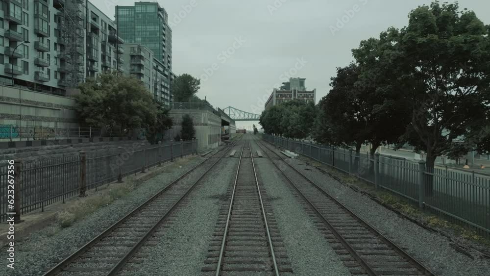 Frontal pan moving along rails from train POV next to buildings Frontal pan moving along rails from train POV next to buildings