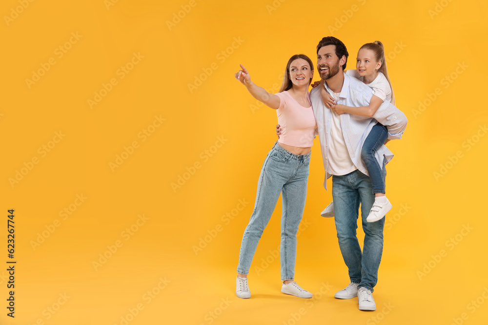 Fototapeta premium Happy family on orange background, space for text