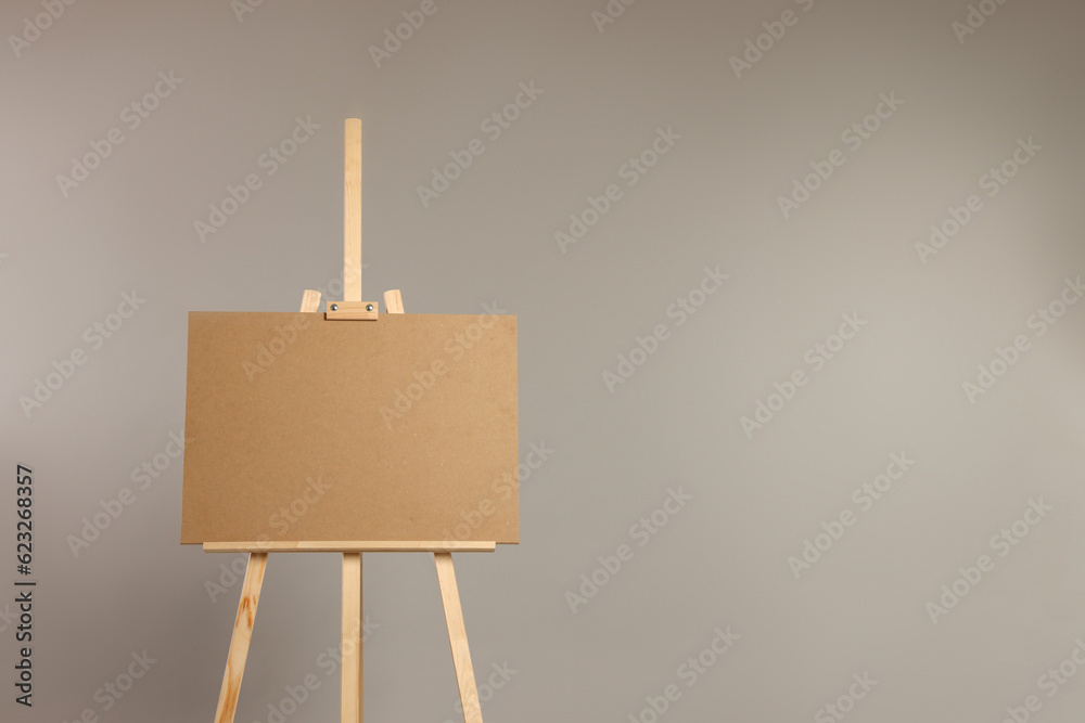 Wooden easel with blank board on grey background. Space for text Wooden easel with blank board on grey background. Space for text