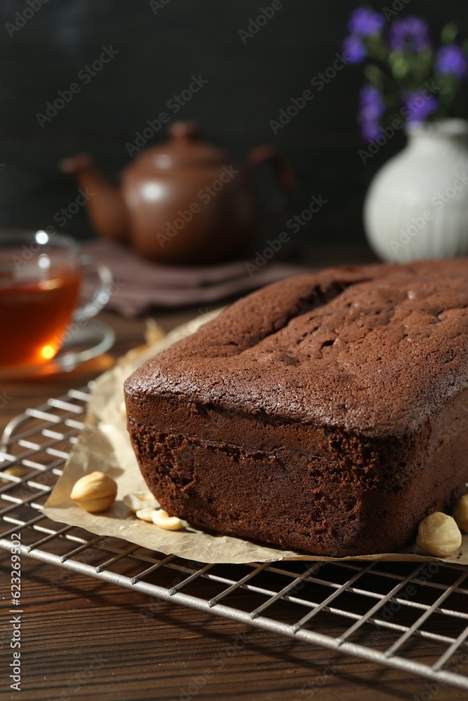 Delicious chocolate sponge cake and nuts on wooden table, closeup Delicious chocolate sponge cake and nuts on wooden table, closeup