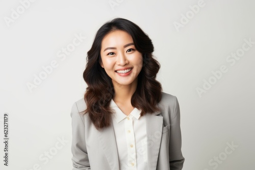 Portrait of a smiling asian businesswoman standing against white background