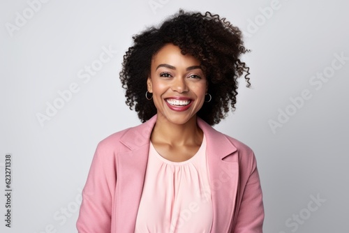 Smiling african american woman with curly hairstyle and pink jacket