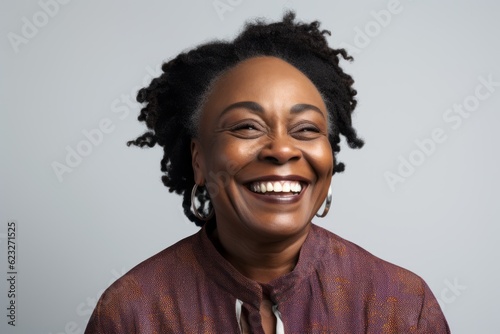 Portrait of a happy african american woman laughing over gray background