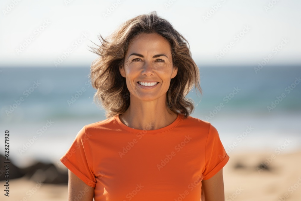 Portrait of a smiling young woman in orange t-shirt on the beach Portrait of a smiling young woman in orange t-shirt on the beach