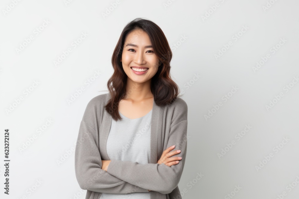 Portrait of a smiling young asian woman with arms crossed on white background Portrait of a smiling young asian woman with arms crossed on white background
