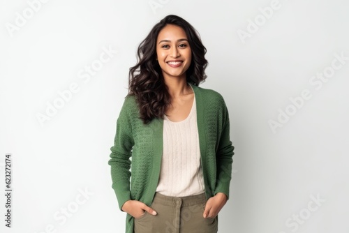 Portrait of a happy young woman standing with hands in pockets over white background