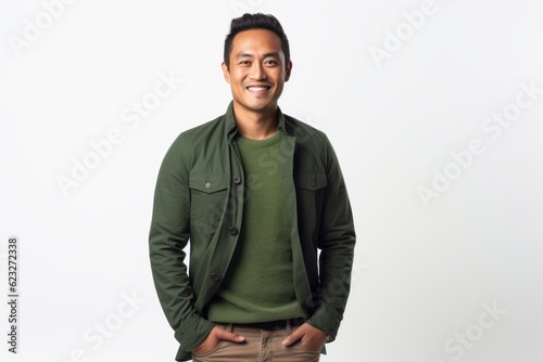 Portrait of a happy young asian man standing with hands in pockets