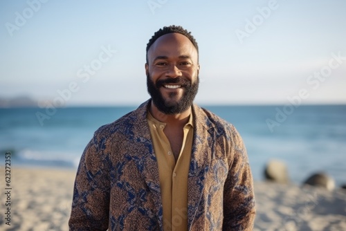 Portrait of happy young man standing on beach at the day time