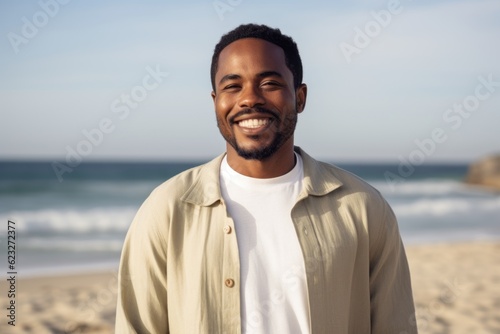 Portrait of smiling african american man standing at beach on a sunny day