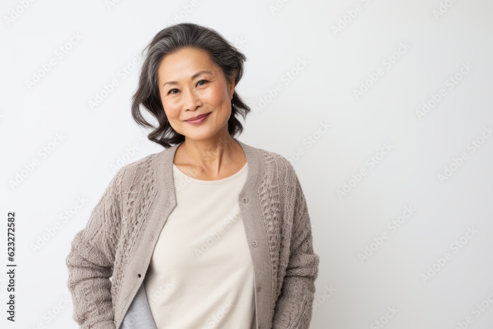 portrait of mature asian woman standing with arms crossed over white background portrait of mature asian woman standing with arms crossed over white background