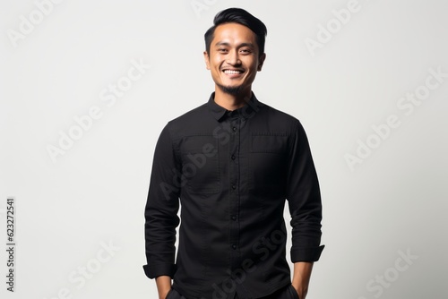 Portrait of a smiling asian man in black shirt on white background