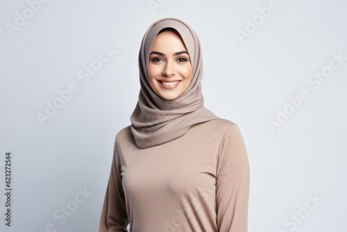 portrait of beautiful young muslim woman in hijab smiling at camera