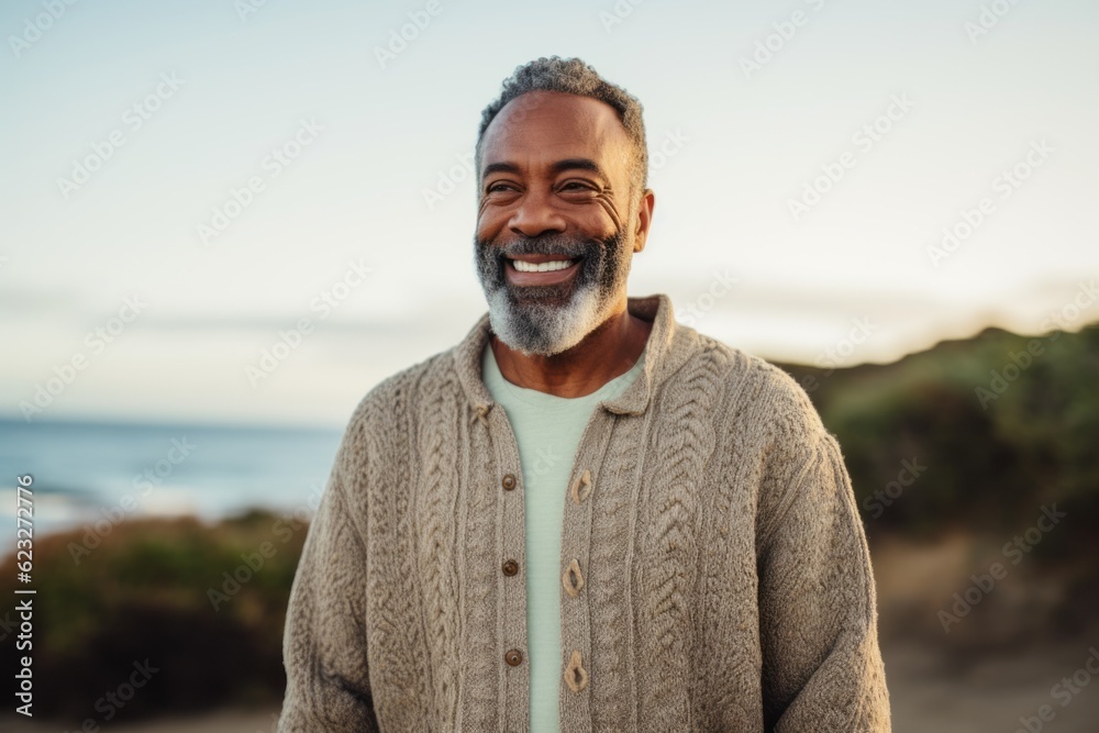 Portrait of smiling senior man standing at beach on a sunny day