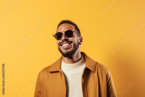 happy african american man in sunglasses looking at camera isolated on yellow