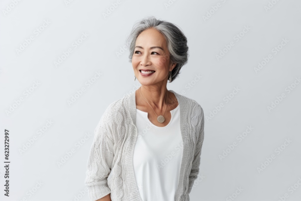 Portrait of a smiling senior asian woman standing isolated over white background Portrait of a smiling senior asian woman standing isolated over white background