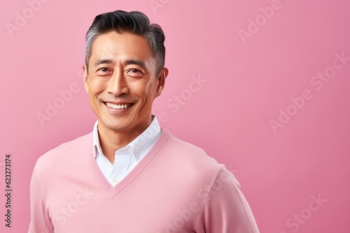 Medium shot portrait photography of a pleased Chinese man in his 40s wearing a chic cardigan against a pastel or soft colors background  © Leon Waltz