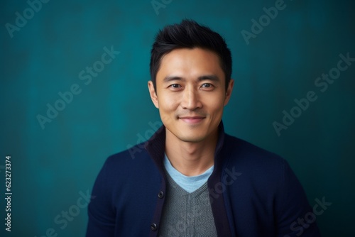 Medium shot portrait photography of a satisfied Chinese man in his 30s wearing a chic cardigan against an abstract background 