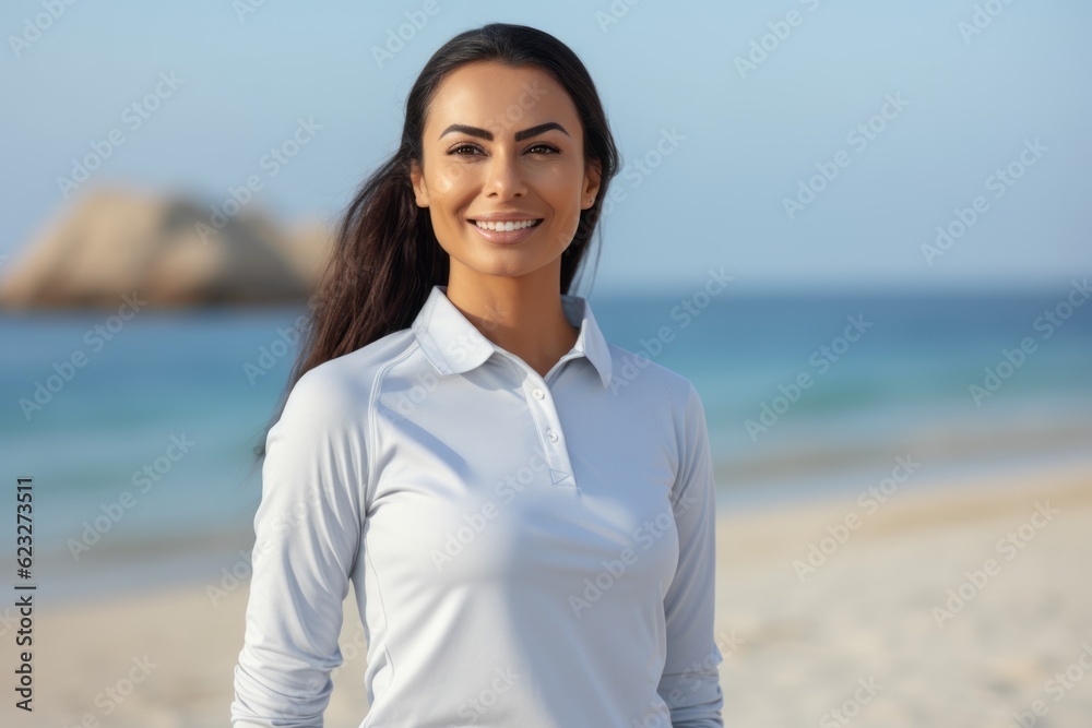 Portrait of a beautiful young woman smiling at the camera while standing on the beach Portrait of a beautiful young woman smiling at the camera while standing on the beach