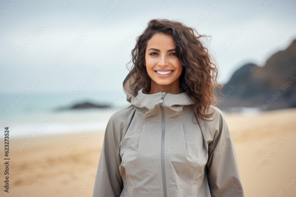 Portrait of a beautiful young woman smiling at the camera on the beach Portrait of a beautiful young woman smiling at the camera on the beach
