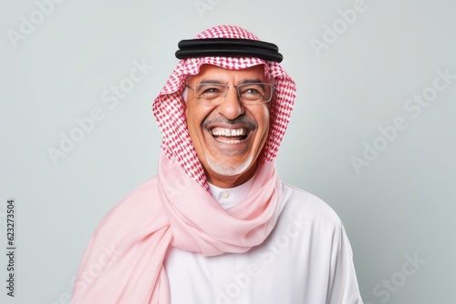 Portrait of a smiling arabian man standing against grey background