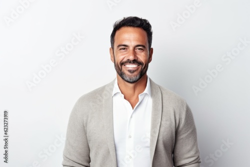 Portrait of a handsome young man smiling at camera while standing against white background