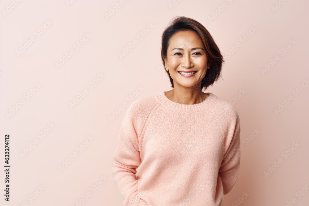 Portrait of a smiling asian woman standing against a pink background Portrait of a smiling asian woman standing against a pink background