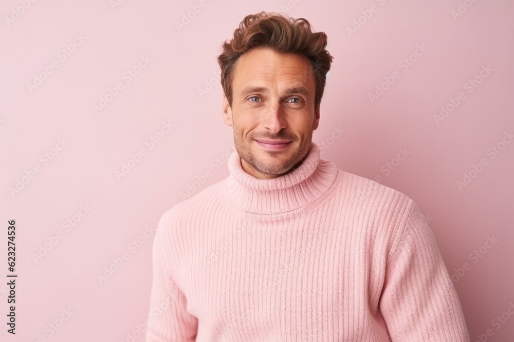 Portrait of handsome man in pink sweater looking at camera and smiling while standing against pink background Portrait of handsome man in pink sweater looking at camera and smiling while standing against pink background