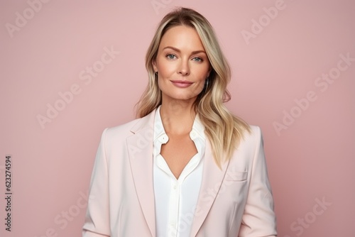 Portrait of a beautiful blonde woman in a pink suit on a pink background