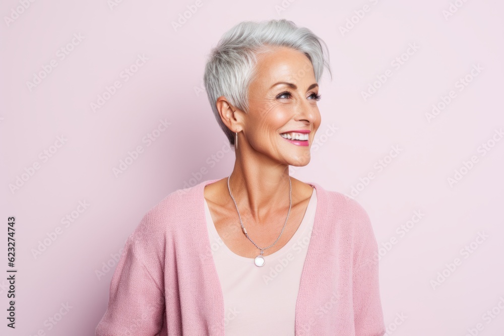 Portrait of a beautiful senior woman smiling at the camera on a pink background Portrait of a beautiful senior woman smiling at the camera on a pink background