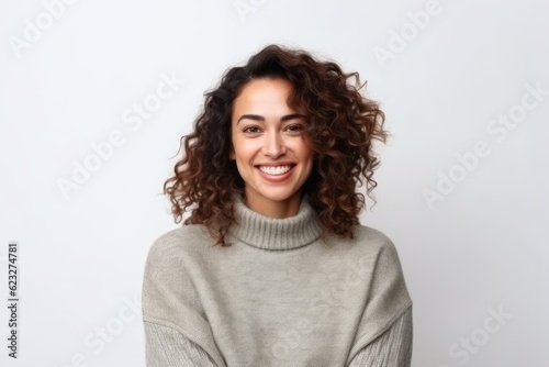 Portrait of a beautiful young woman with curly hair smiling over white background
