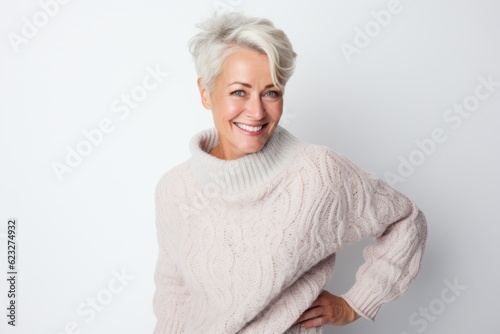 Portrait of a beautiful senior woman in sweater on white background.