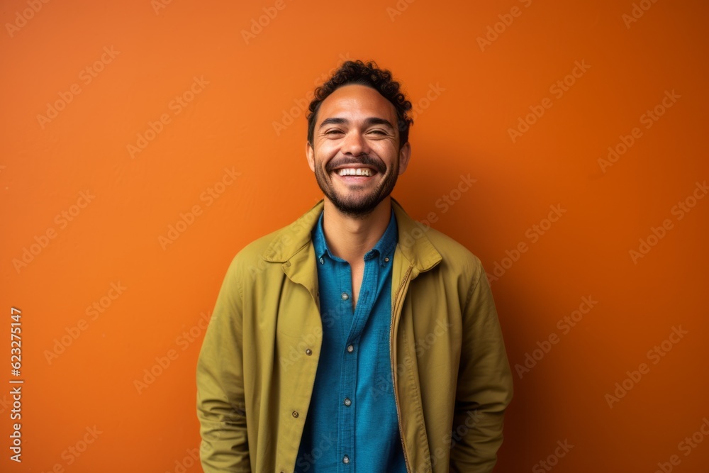Portrait of a happy young african american man on orange background